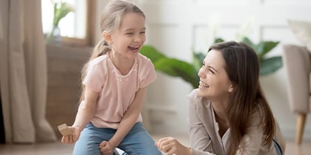 Nounou et petite fille jouant ensemble dans un salon