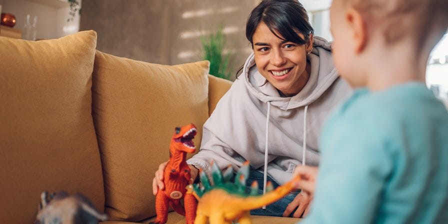 Nounou étudiante fait un spectacle à un petit garçon avec ses figurines