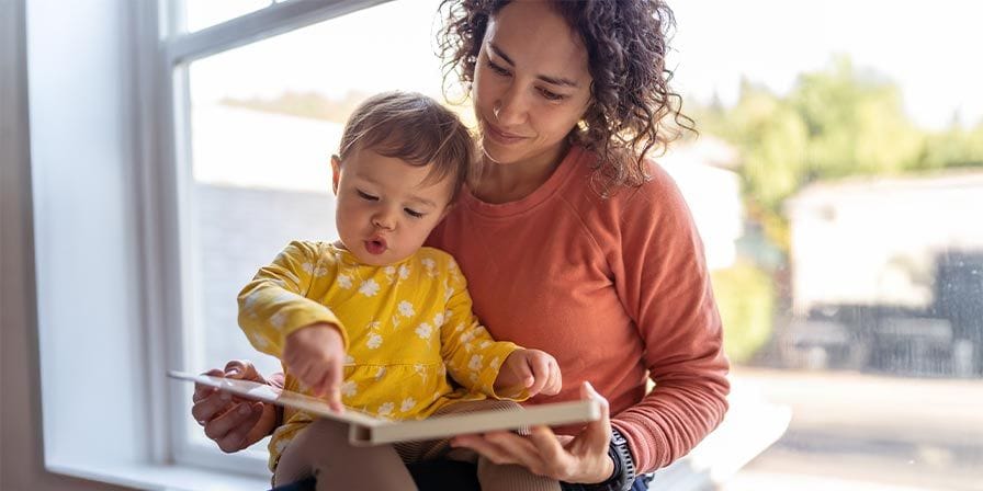 Nounou qui fait une activité lecture avec un enfant