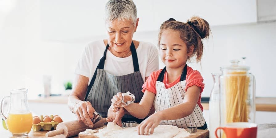Nounou retraitée fait de la pâtisserie avec 1 petite fille