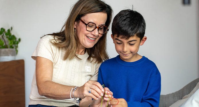 Nounou retraitée aide un petit garçon durant son activité 