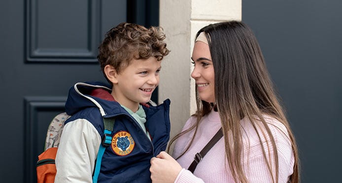 Nounou accompagne un petit garçon à l’école le matin