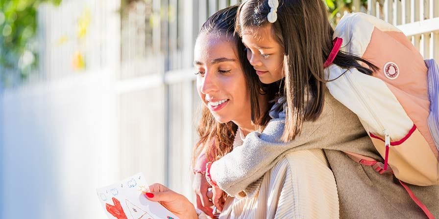 Petite fille sur le dos de sa nounou à la sortie d'école