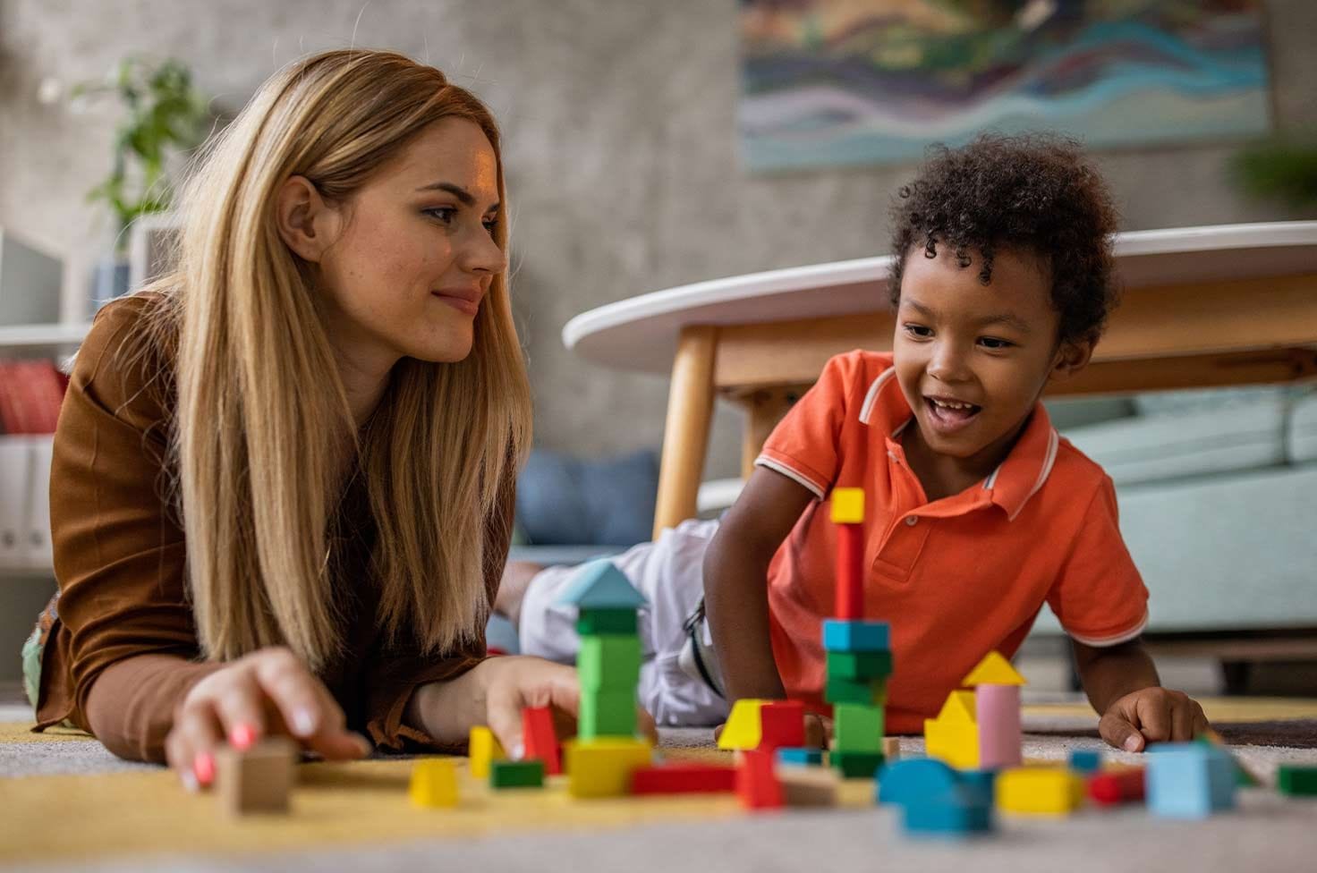 Nounou qui joue avec un petit garçon métisse 