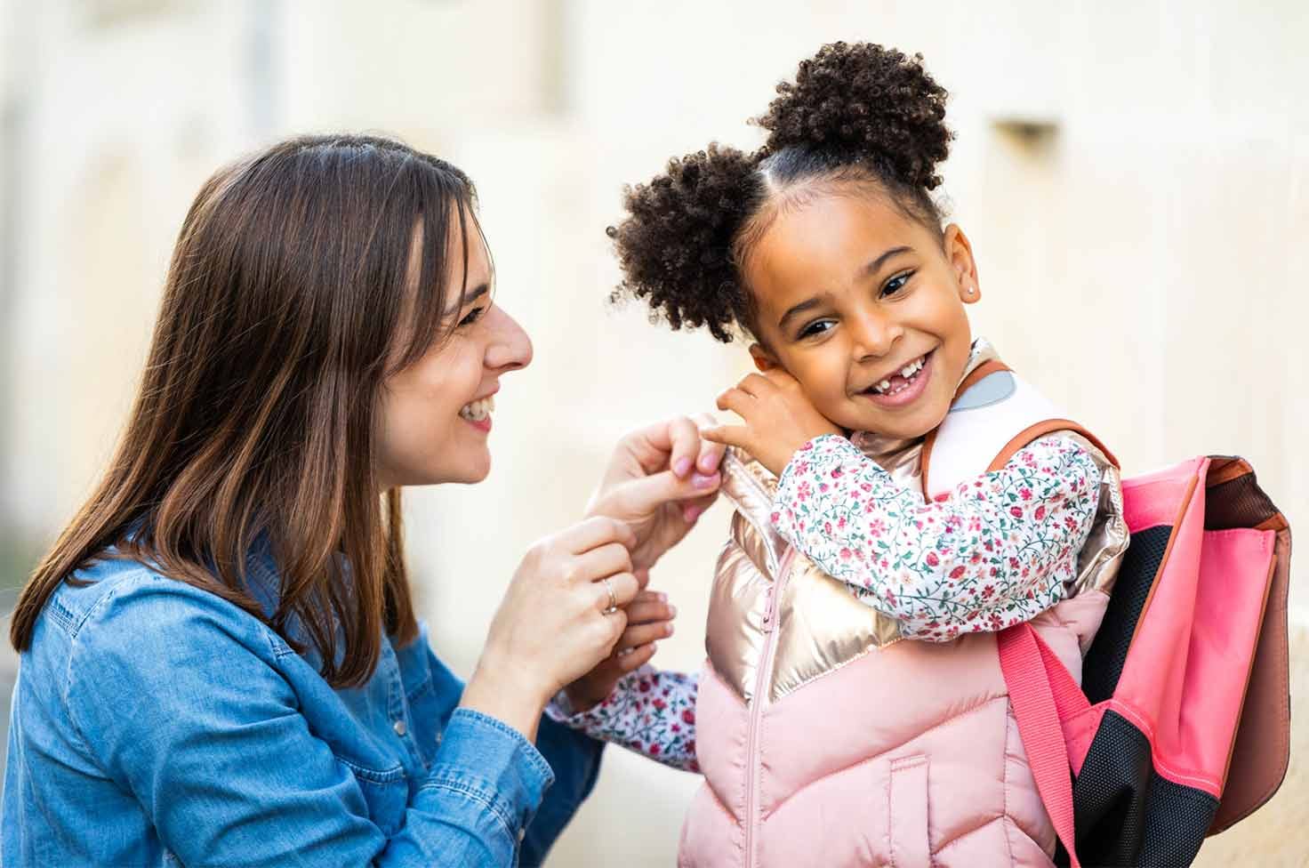 Nounou allant chercher une petite fille métisse à la sortie de l'école