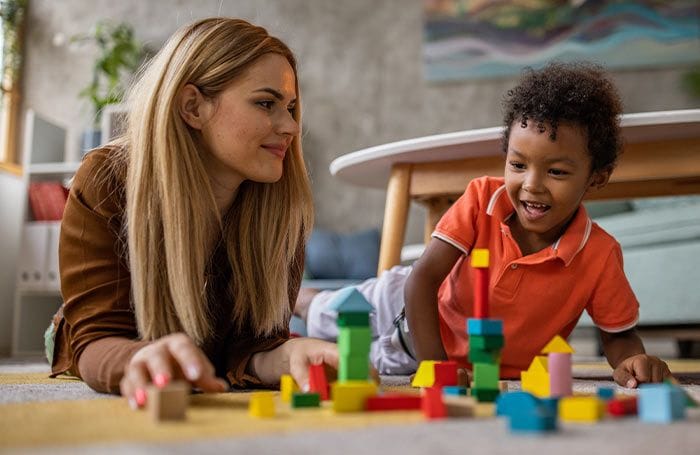 Nounou qui joue avec un petit garçon métisse 