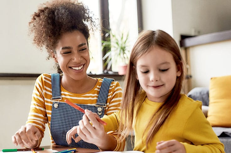 Nounou et petite fille font du coloriage
