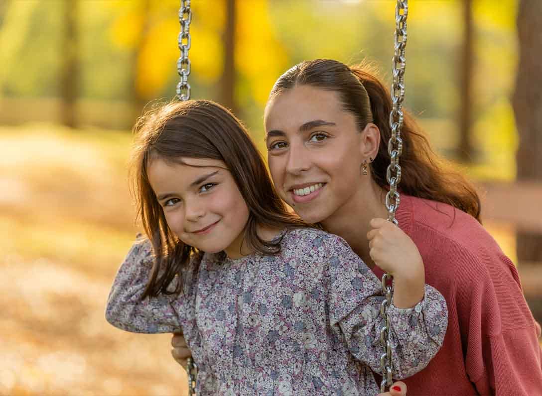 Petite fille sur une balançoire accompagnée de sa nounou