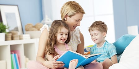 Nounou partageant un moment de lecture avec deux enfants joyeux