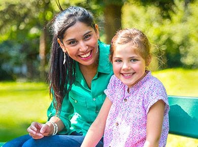 Nounou et petite fille souriantes au parc sur un banc