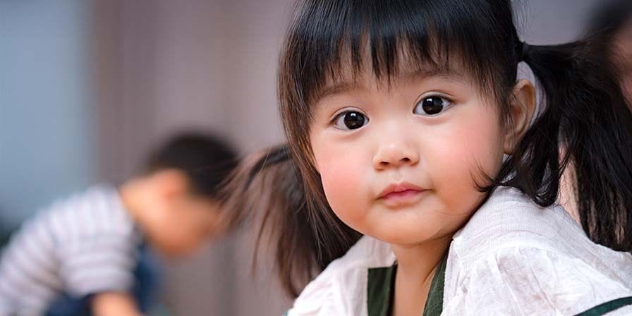 Petite fille asiatique qui regarde la caméra
